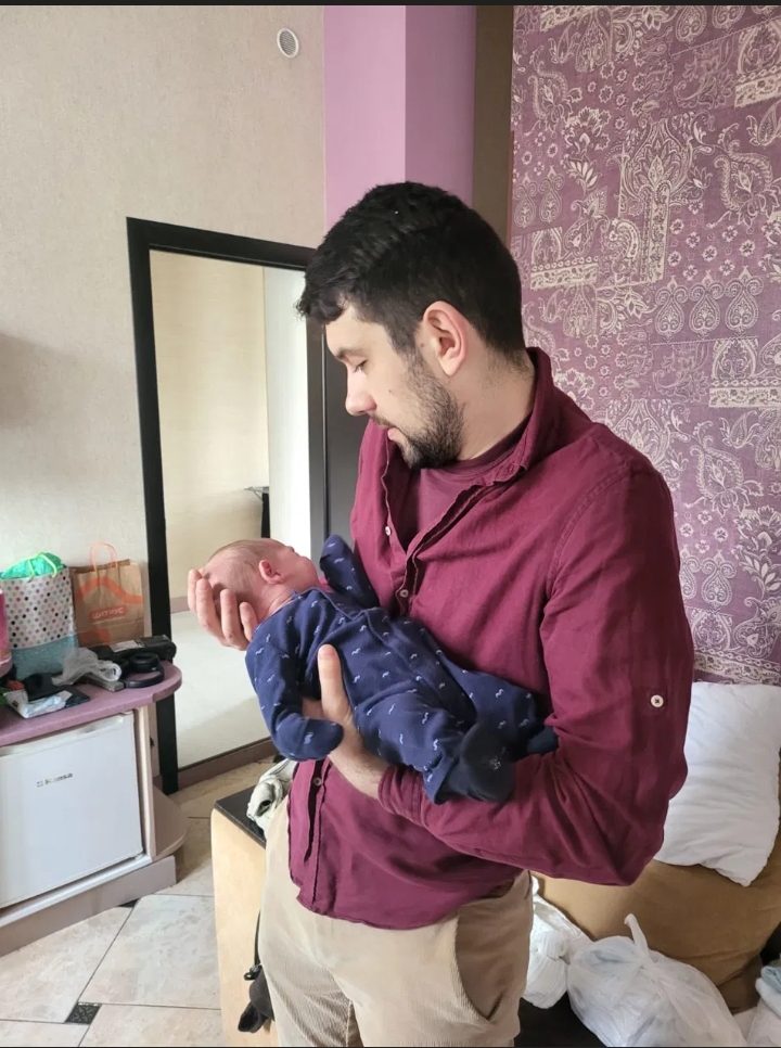Andrew Khodonovych holding a newborn baby — a moment from a Novaparent surrogacy journey in Ukraine